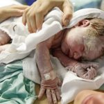 Новорожденный лежит на матери